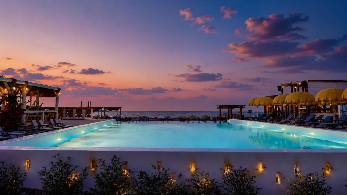 Main pool at sunset with purple sky and glowing water