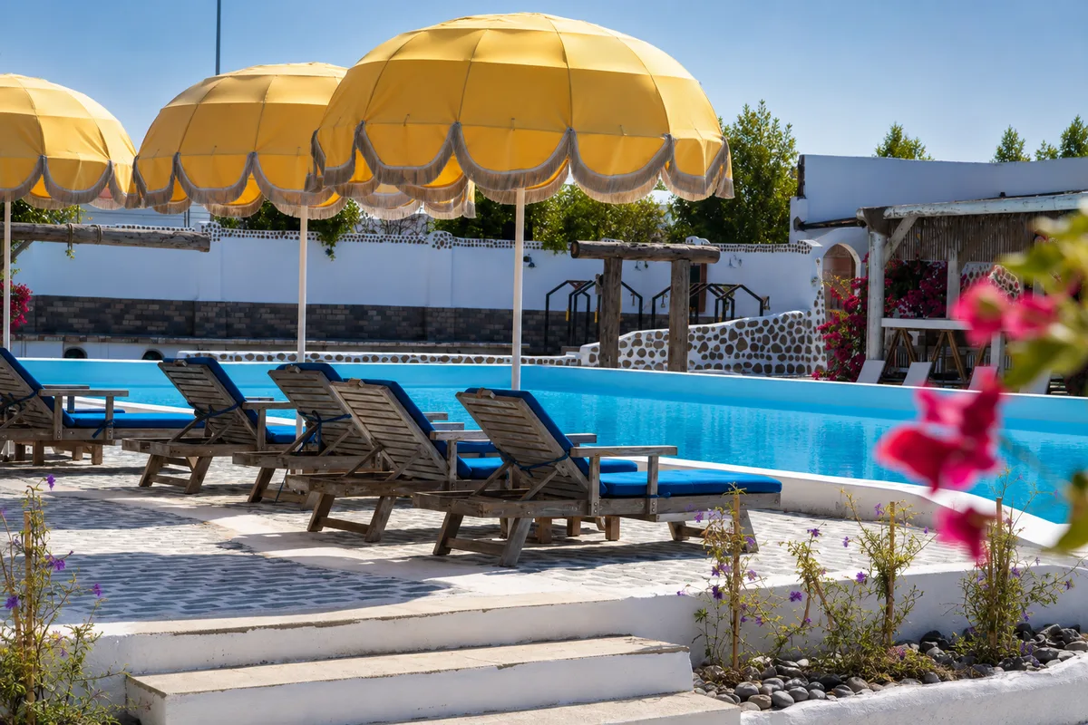 Pool terrace with yellow umbrellas and navy loungers
